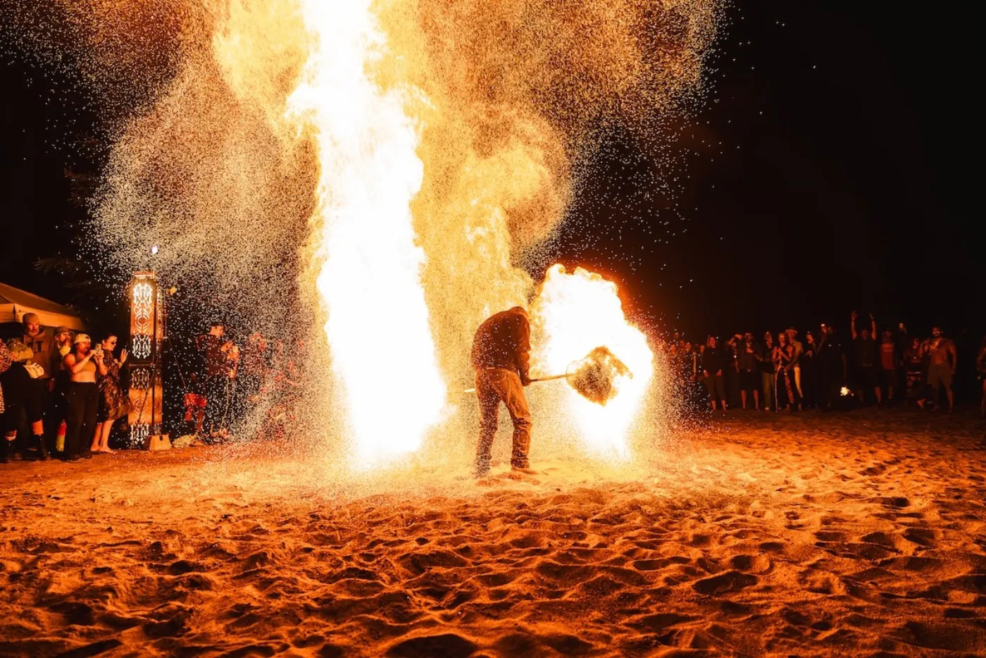 Spectacle de feu sur la plage, la nuit, devant les festivaliers